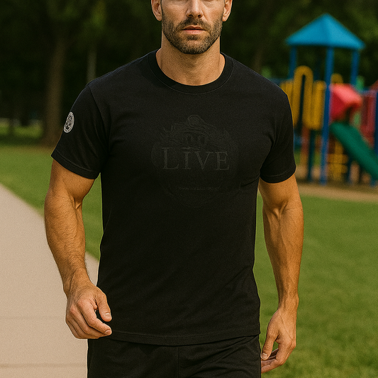 Man wearing a black t-shirt with 'LIVE' logo outdoors on a path